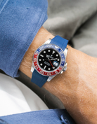 Close-up of a person wearing a Rolex GMT Master 2 Pepsi model watch with  blue jacket sleeve and a navy blue vertech FKM rubber watch strap from Wristbuddys
