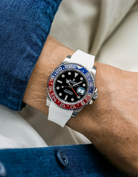 Close-up of a person wearing a Rolex GMT Master 2 Pepsi model watch with  blue jacket sleeve and a white vertech FKM rubber watch strap from Wristbuddys