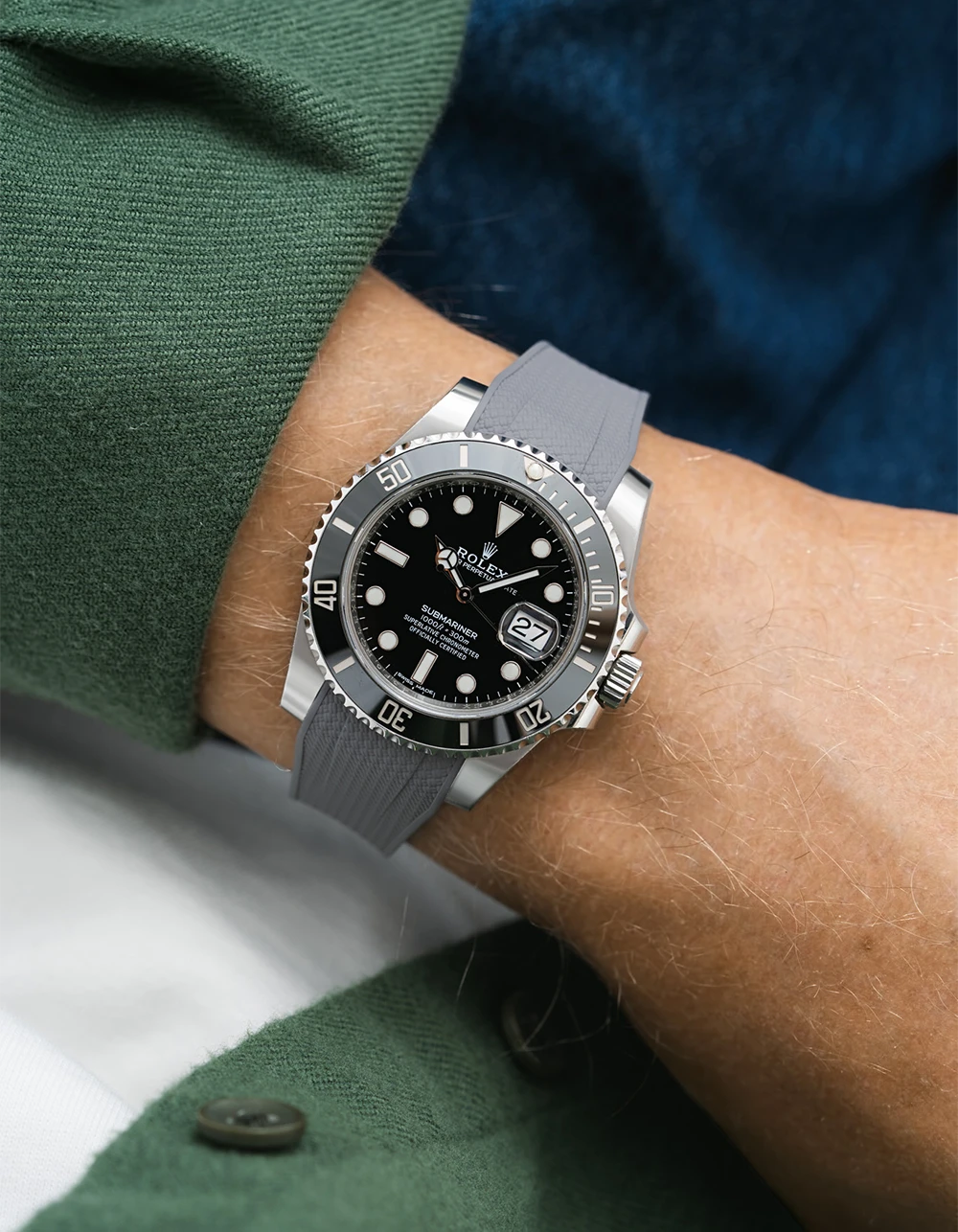 Person wearing a Rolex Submariner on a grey vertech Wristbuddys FKM Rubber watch strap on a green and blue checkered shirt.