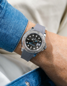 Close-up of a person wearing a Rolex YachtMaster 2 126622 / 116622 model watch with a blue shirt sleeve and a grey FKM rubber watch strap from Wristbuddys