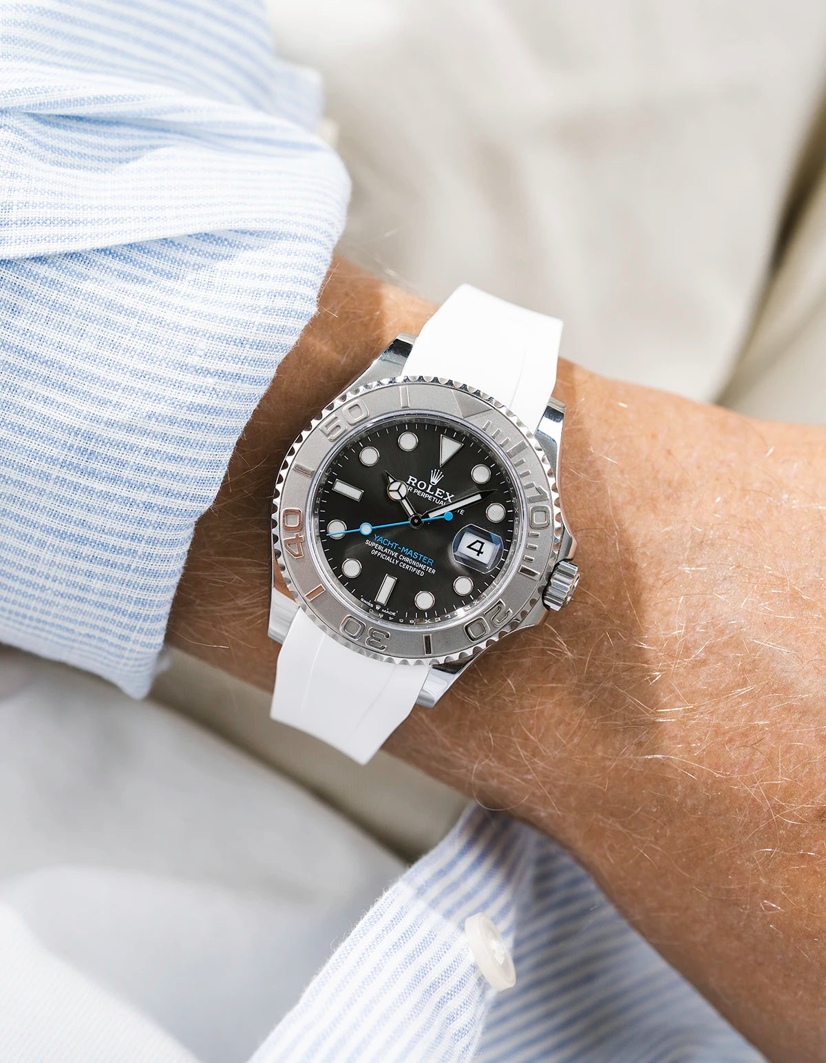 Close-up of a person wearing a Rolex YachtMaster 2 126622 / 116622 model watch with a light blue shirt sleeve and a white FKM rubber watch strap from Wristbuddys