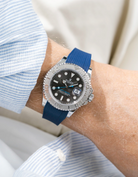 Close-up of a person wearing a Rolex YachtMaster 2 126622 / 116622 model watch with a light blue shirt sleeve and a Blue Vertech FKM rubber watch strap from Wristbuddys