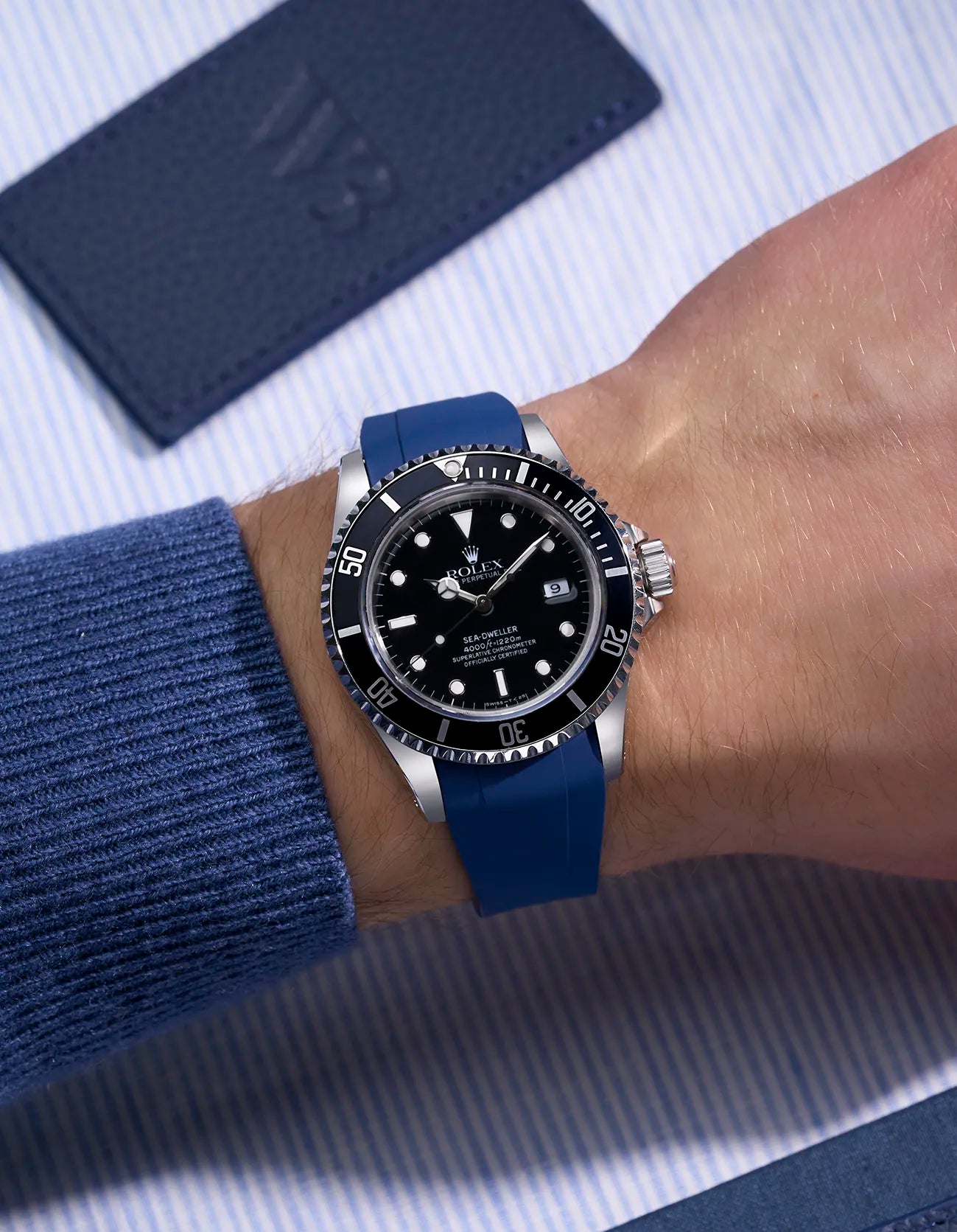 Rolex Sea-Dweller 16600 fitted with integrated blue FKM rubber strap and original clasp, worn on wrist