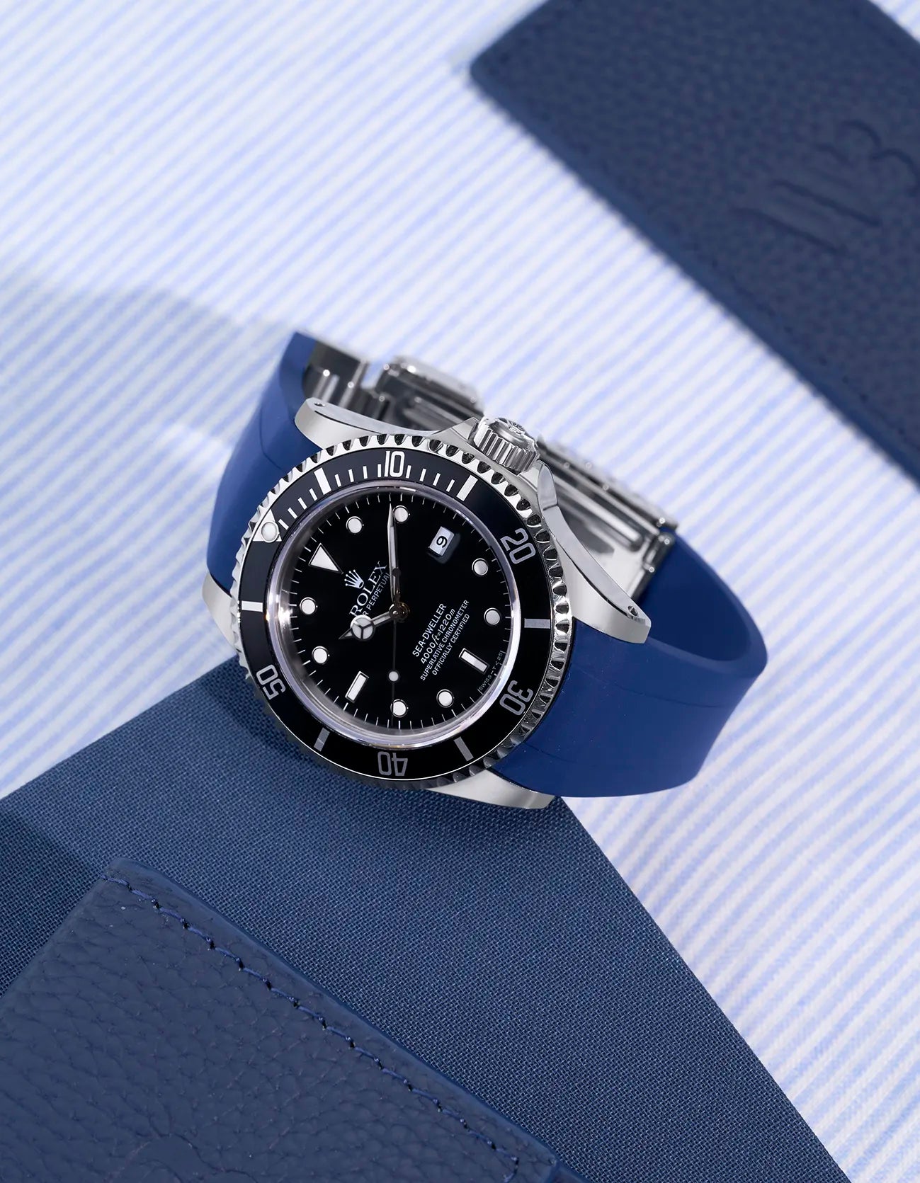 Rolex Sea-Dweller 16600 with integrated blue rubber strap and original clasp shown on fabric background