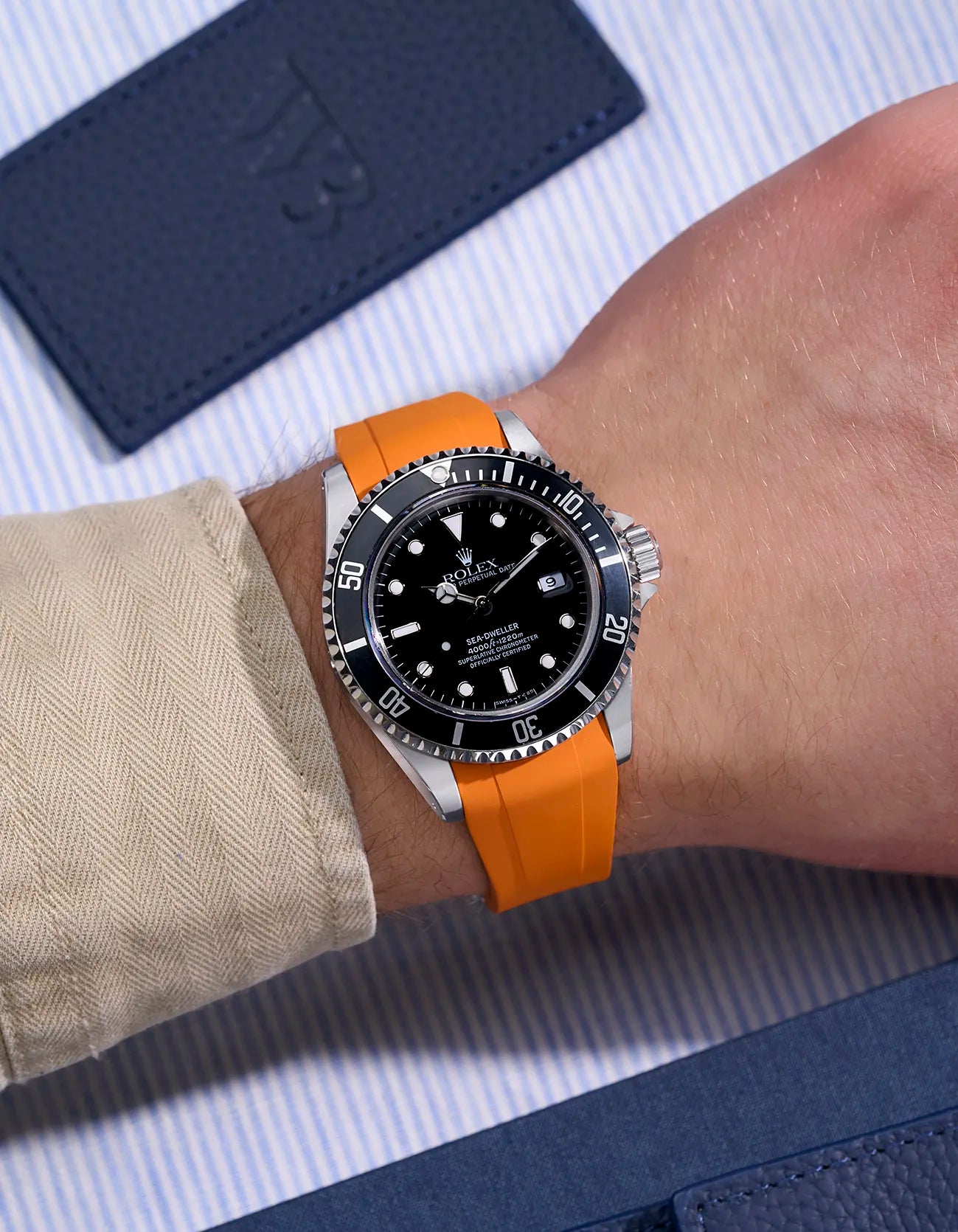 Rolex Sea-Dweller 16600 on wrist with orange FKM rubber strap and integrated original clasp