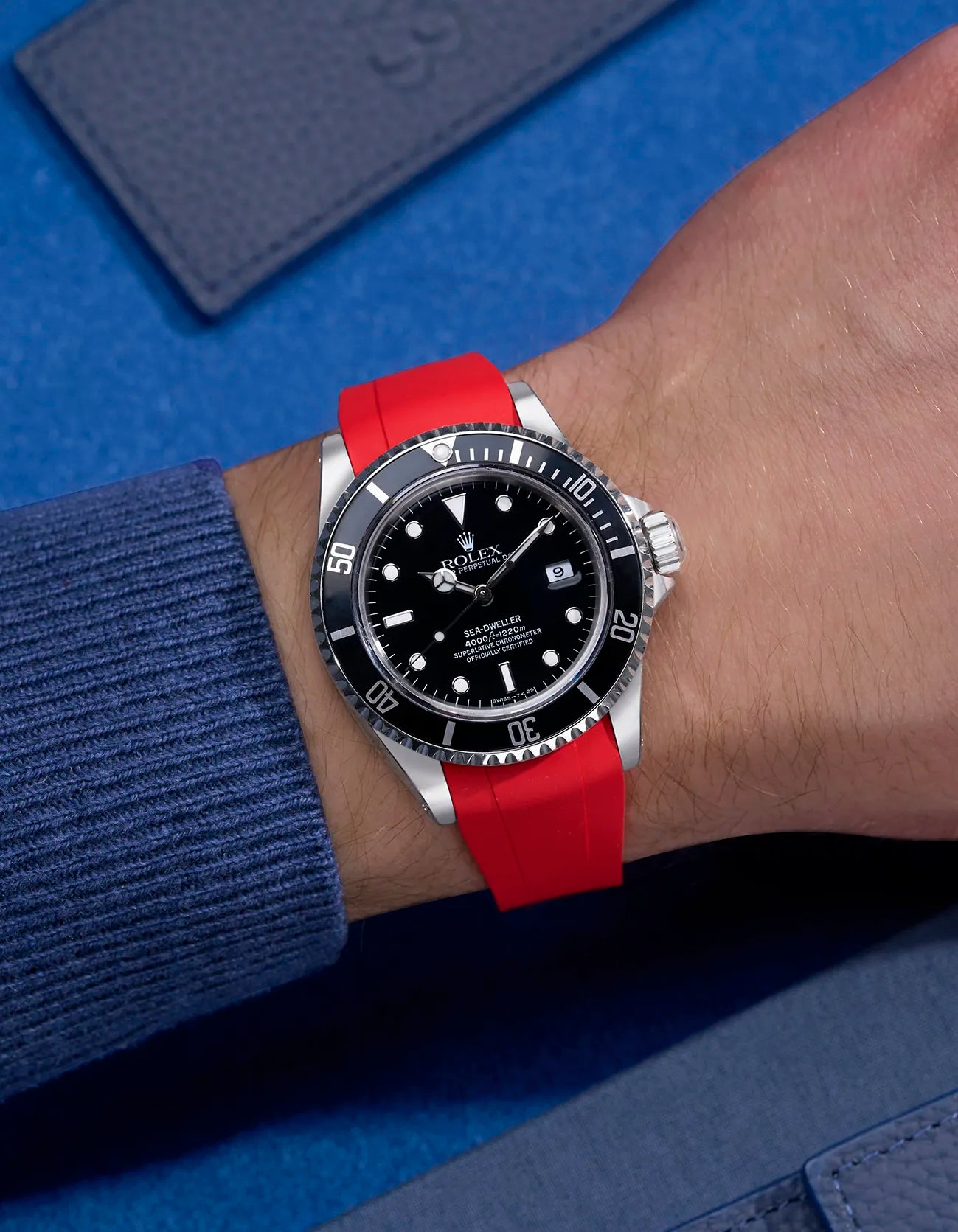 Wrist shot of Rolex Sea-Dweller 16600 on red FKM rubber strap with original clasp integration