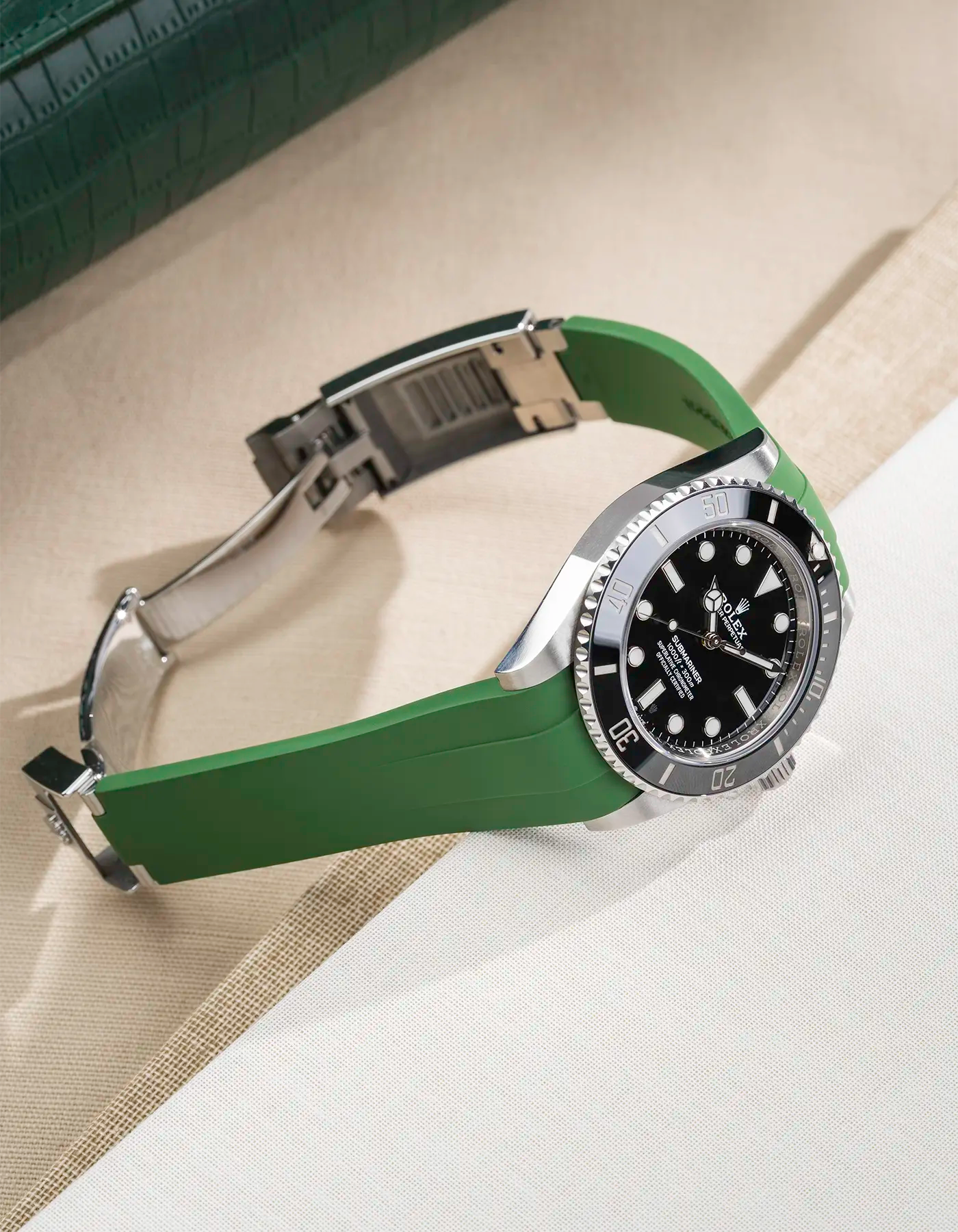 Rolex Submariner 41 with green Classic Smooth FKM Rubber Strap sitting on the watch, integrated with original clasp – lifestyle product photo side angle with clasp open