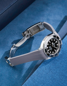 Product photo of Rolex Submariner 41 with grey Vertech FKM Rubber Strap mounted on the watch, integrated with original clasp – side angle view showing clasp open