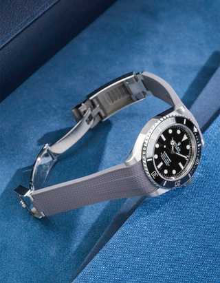 Product photo of Rolex Submariner 41 with grey Vertech FKM Rubber Strap mounted on the watch, integrated with original clasp – side angle view showing clasp open