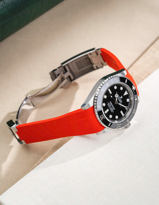 Lifestyle product photo of Rolex Submariner 41 with red Classic Smooth FKM Rubber Strap attached to the watch, integrated with original clasp – side angle view, clasp open