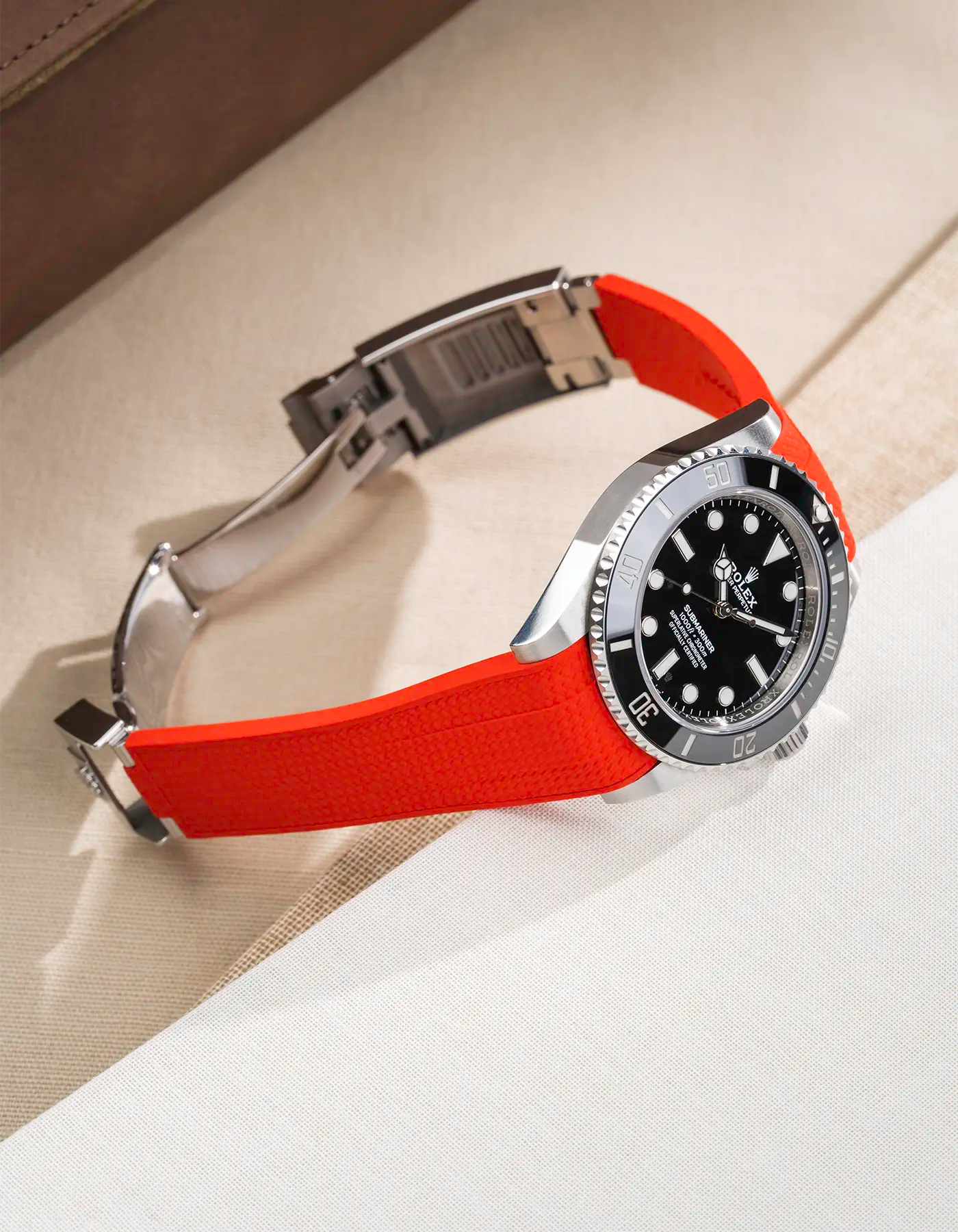 Rolex Submariner 41 (126610LN/124060LN) shown with red Vertech FKM Rubber Strap mounted on the watch, original clasp open – lifestyle side shot