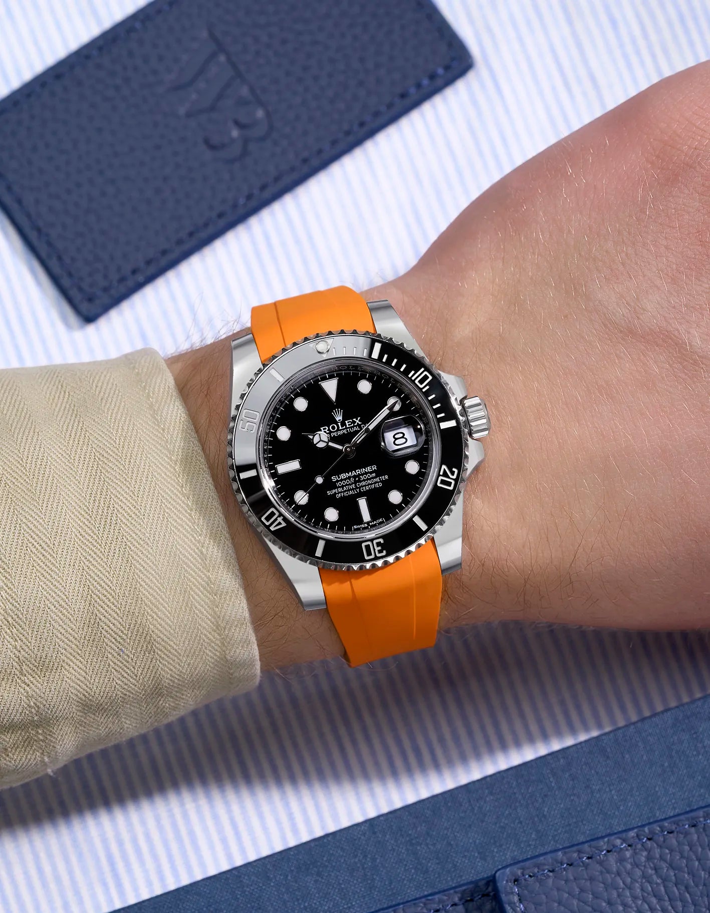 Rolex Submariner 116610LN on wrist with vibrant orange rubber strap and original clasp integration