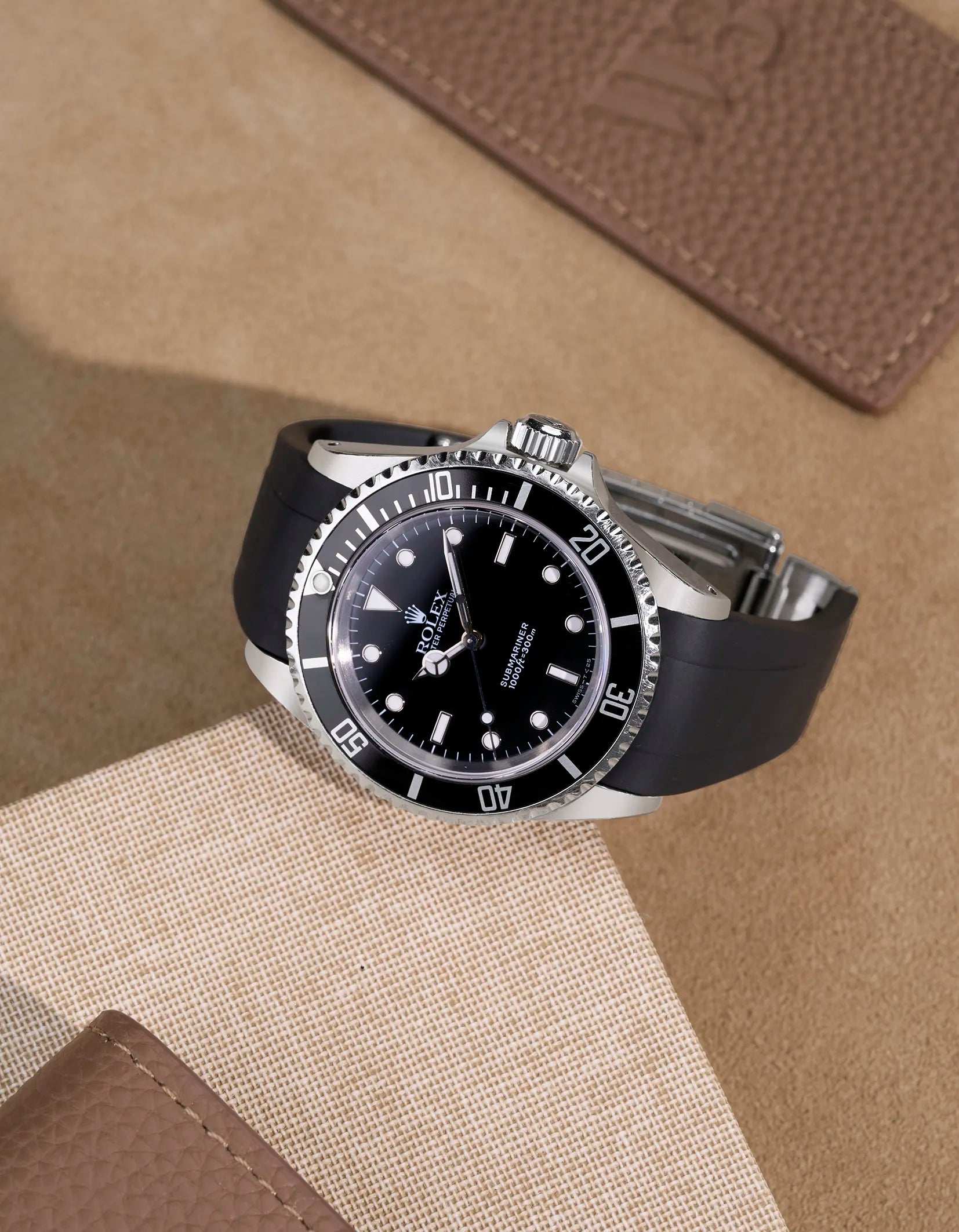 Rolex Submariner 16610/14060 with black FKM strap – flat lay showcasing original clasp integration and sporty luxury look