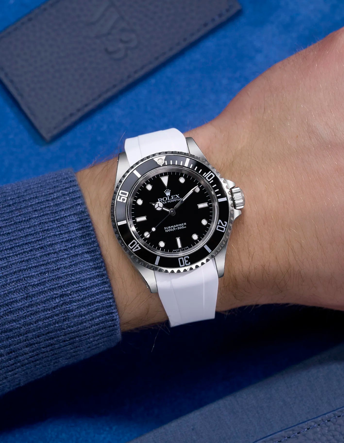 Wrist shot of Rolex Submariner 16610 and 14060 on white integrated FKM rubber strap with original clasp