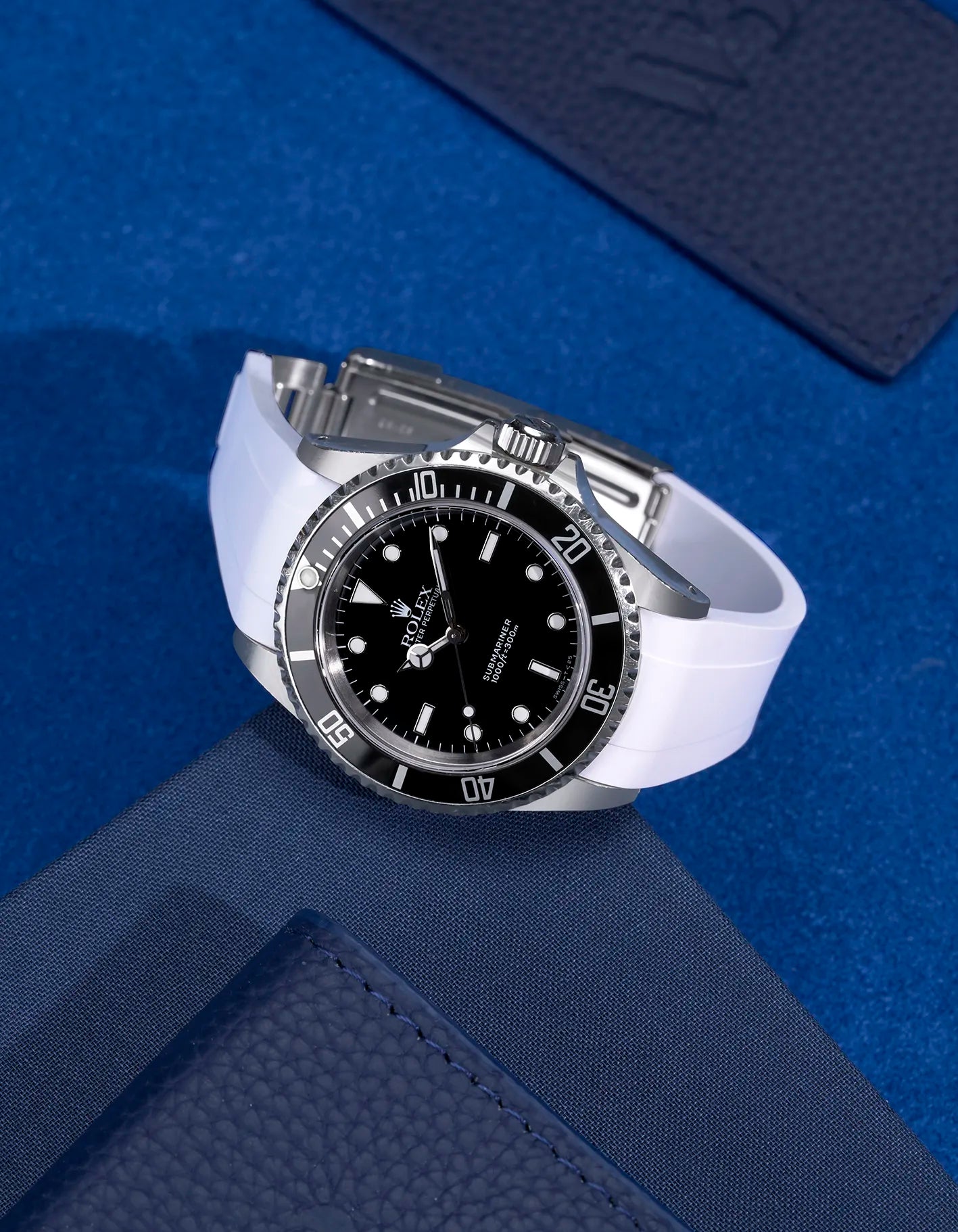 Rolex Submariner 16610 and 14060 on white FKM rubber strap integrated with original clasp – display on blue fabric