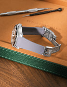 Grey Vertech FKM rubber strap for Rolex Submariner 116610 and 126610, integrated fit for original clasp, resting on a leather valet tray.