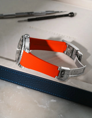 Red Vertech FKM rubber strap for Rolex Submariner 116610 and 126610, integrated fit for original clasp, resting on a leather valet tray