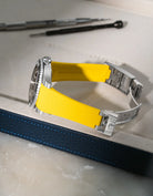 Yellow Vertech FKM rubber strap for Rolex Submariner 116610 and 126610, integrated fit for original clasp, resting on a leather valet tray.