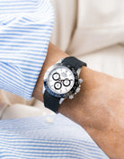 Vertech black integrated FKM rubber strap with original clasp on Rolex Daytona 116500 white dial ceramic bezel wrist shot with blue and white shirt