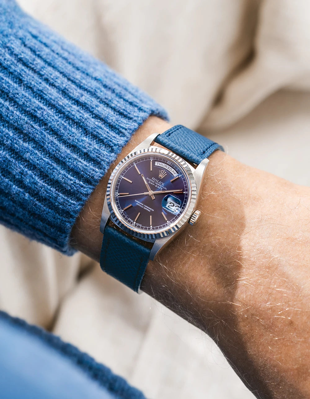 Rolex DayDate in white gold with a blue epsom leather watch strap from Wristbuddys on a wrist, wearing a blue sleeve.