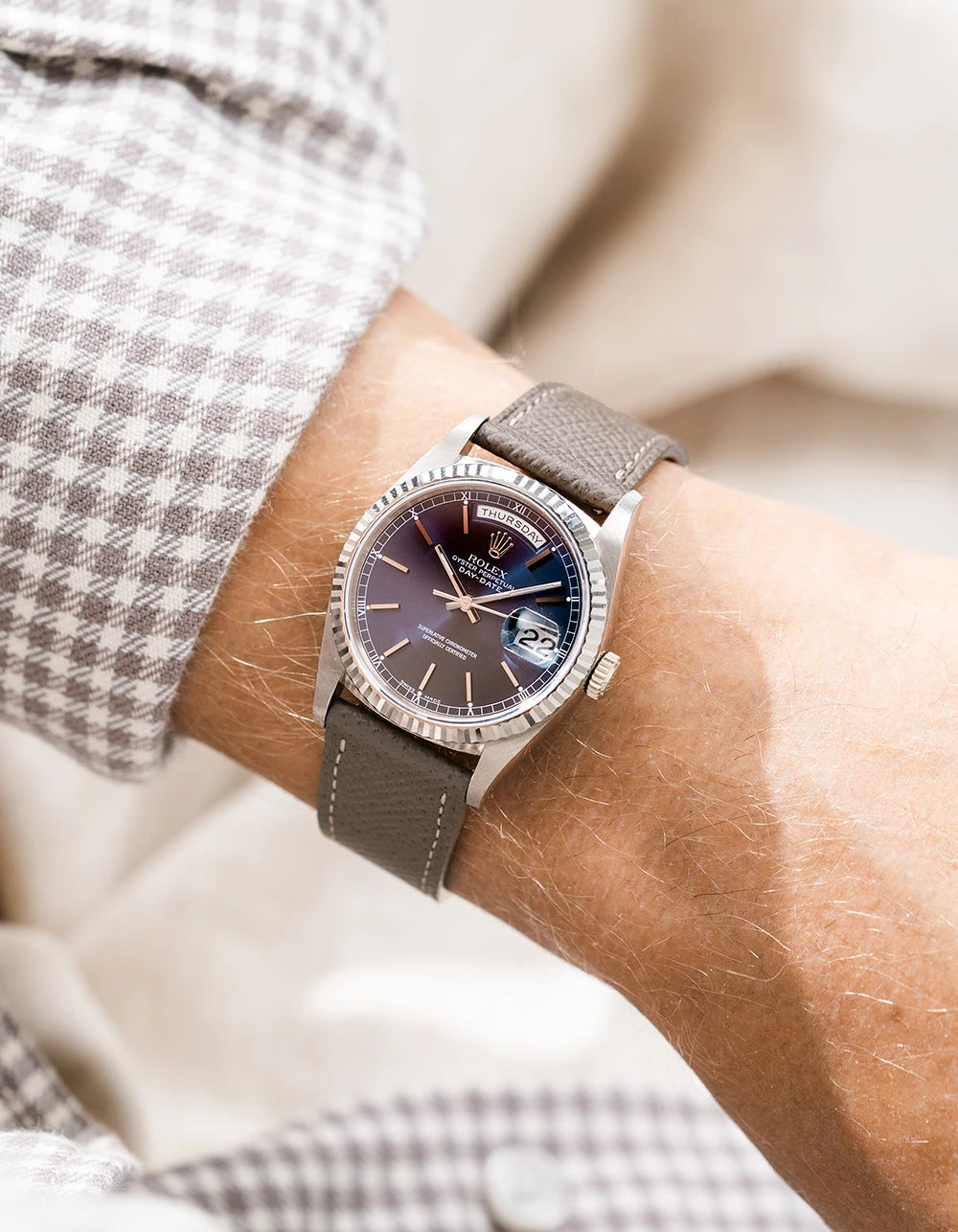 Rolex DayDate in white gold with a grey epsom leather watch strap from Wristbuddys on a wrist, wearing sleeve.