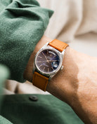 Rolex DayDate in white gold with a brown epsom leather watch strap from Wristbuddys on a wrist, wearing green sleeve.