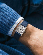 Cartier Tank Solo with a navy blue calfskin leather watch strap from Wristbuddys on a wrist, wearing a blue shirt.