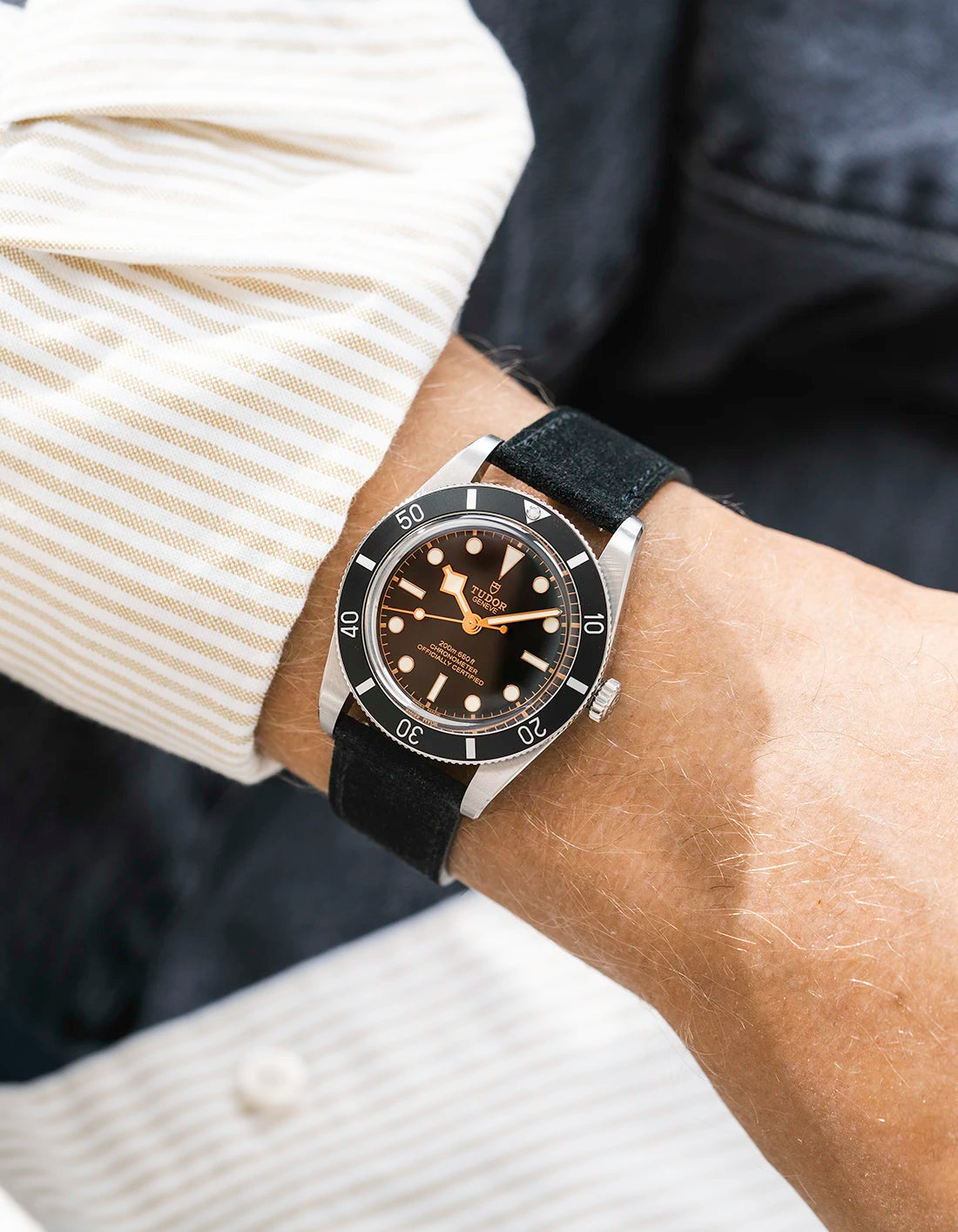 Tudor BB54 with a balck suede leather strap from Wristbuddys on a wrist, wearing a beige sleeve.