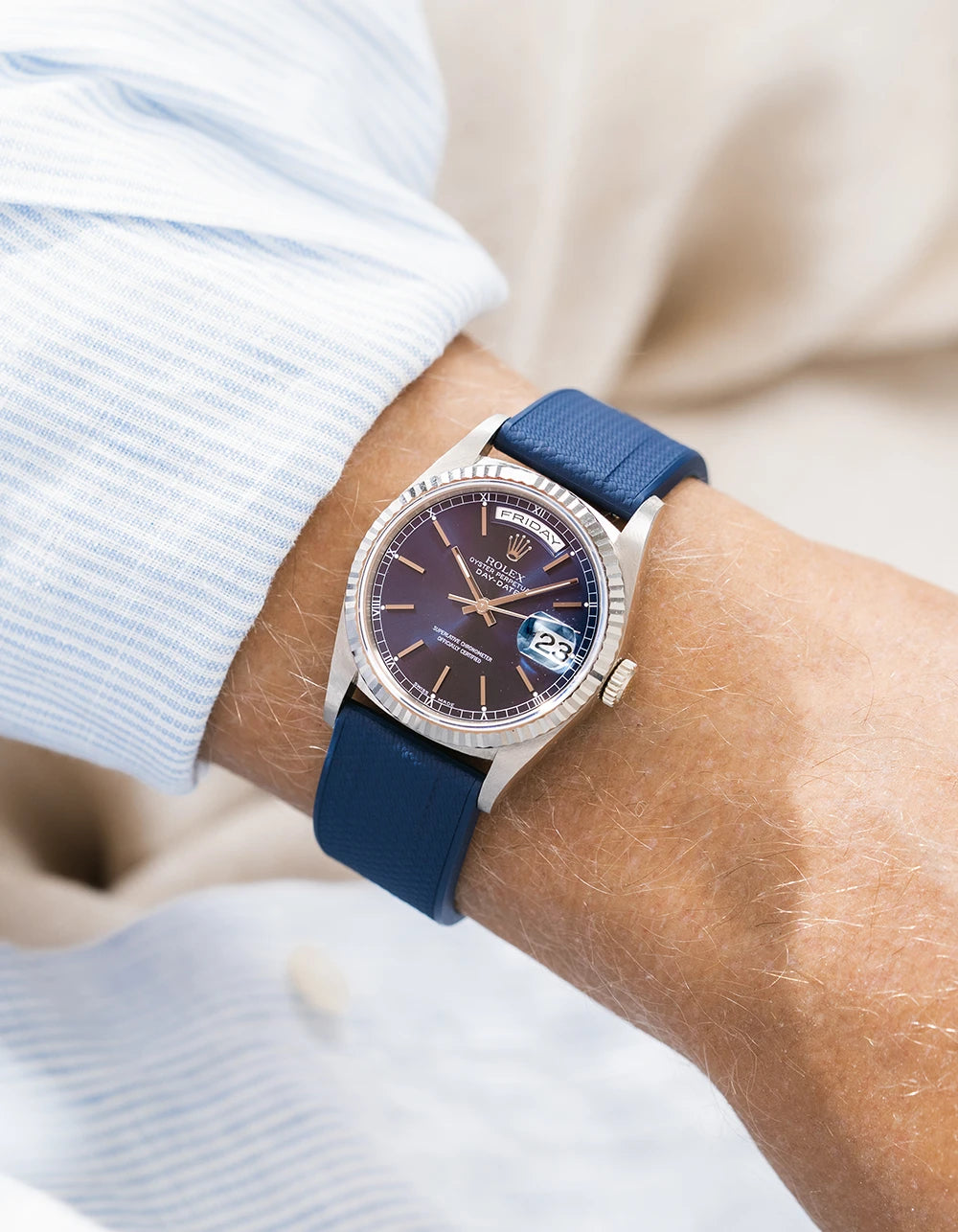 Straight end FKM Rubber watch strap from Wristbuddys on a Rolex DayDate with a blue dial and white gold case on a persons wrist close up. 