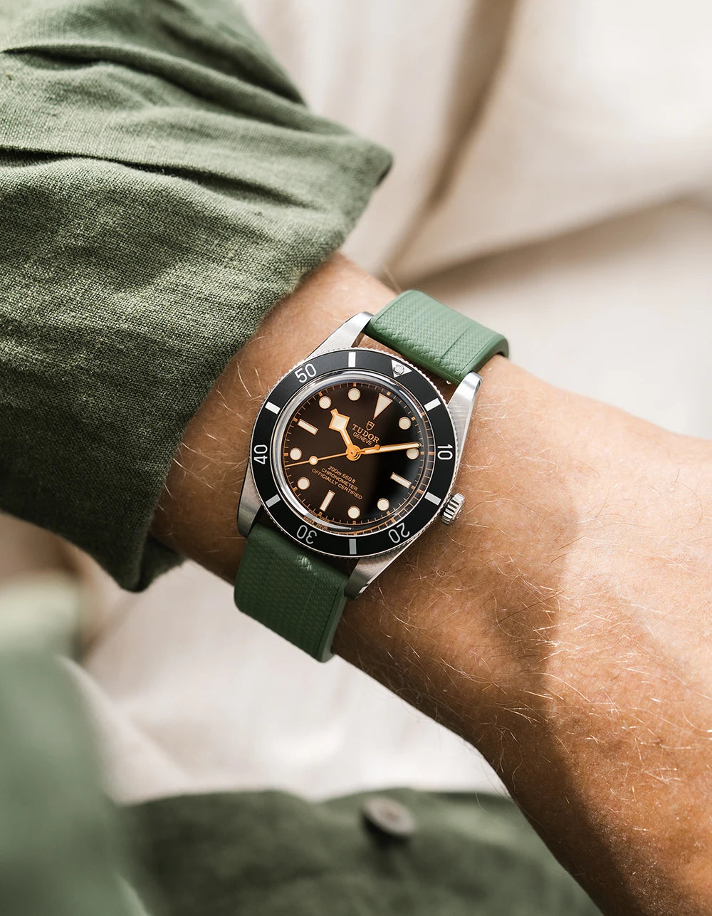 Green FKM Straight end watch strap from Wristbuddys on a Tudor BB54 with a detailed face on a person's wrist, wearing a green shirt.