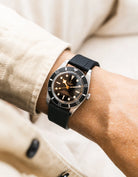 Black FKM Straight end watch strap from Wristbuddys on a Tudor BB54 with a detailed face on a person's wrist, wearing a beige shirt.