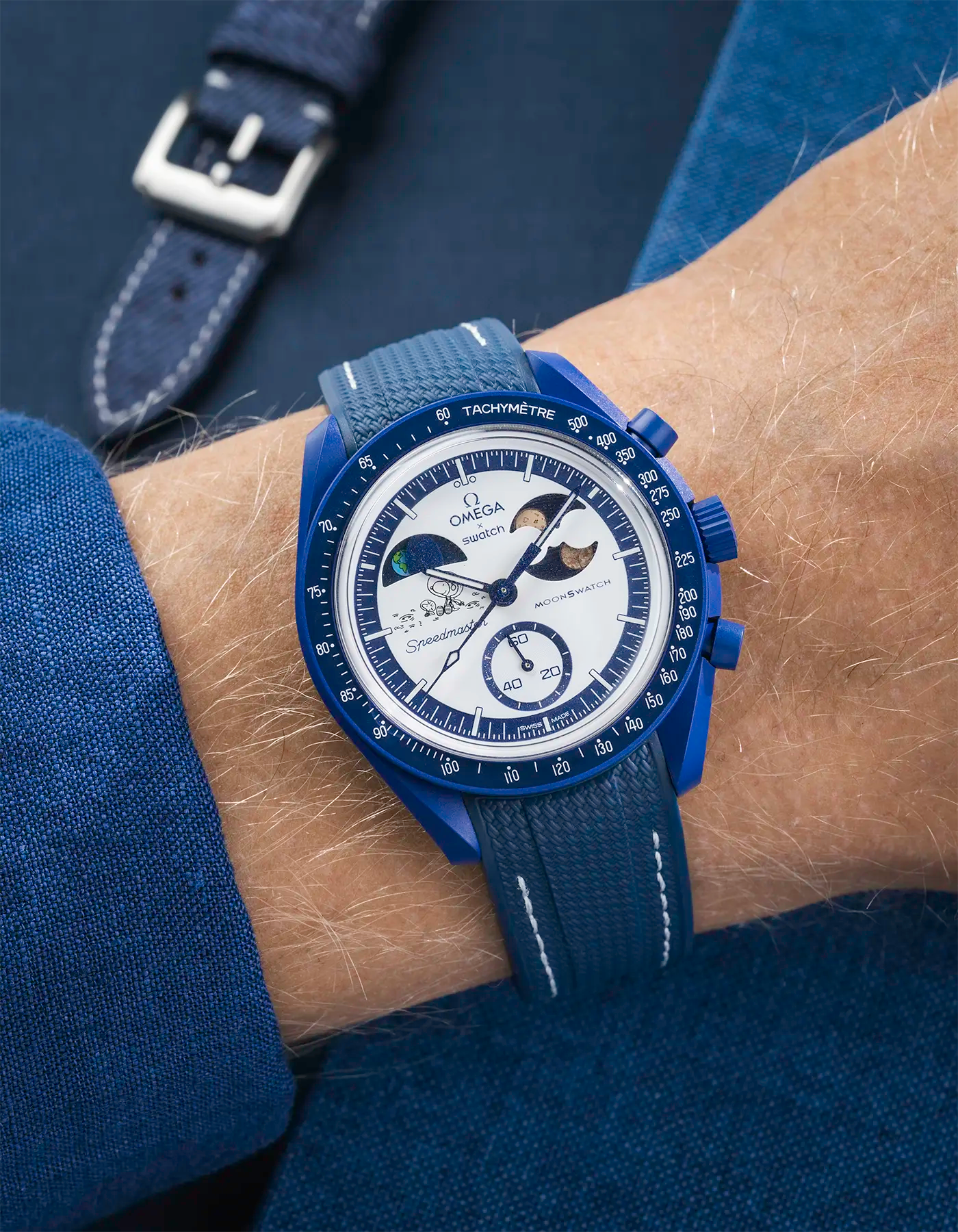 Omega x Swatch MoonSwatch Mission to Earthphase – Moonshine Gold with blue rubber strap and white stitching, wrist shot