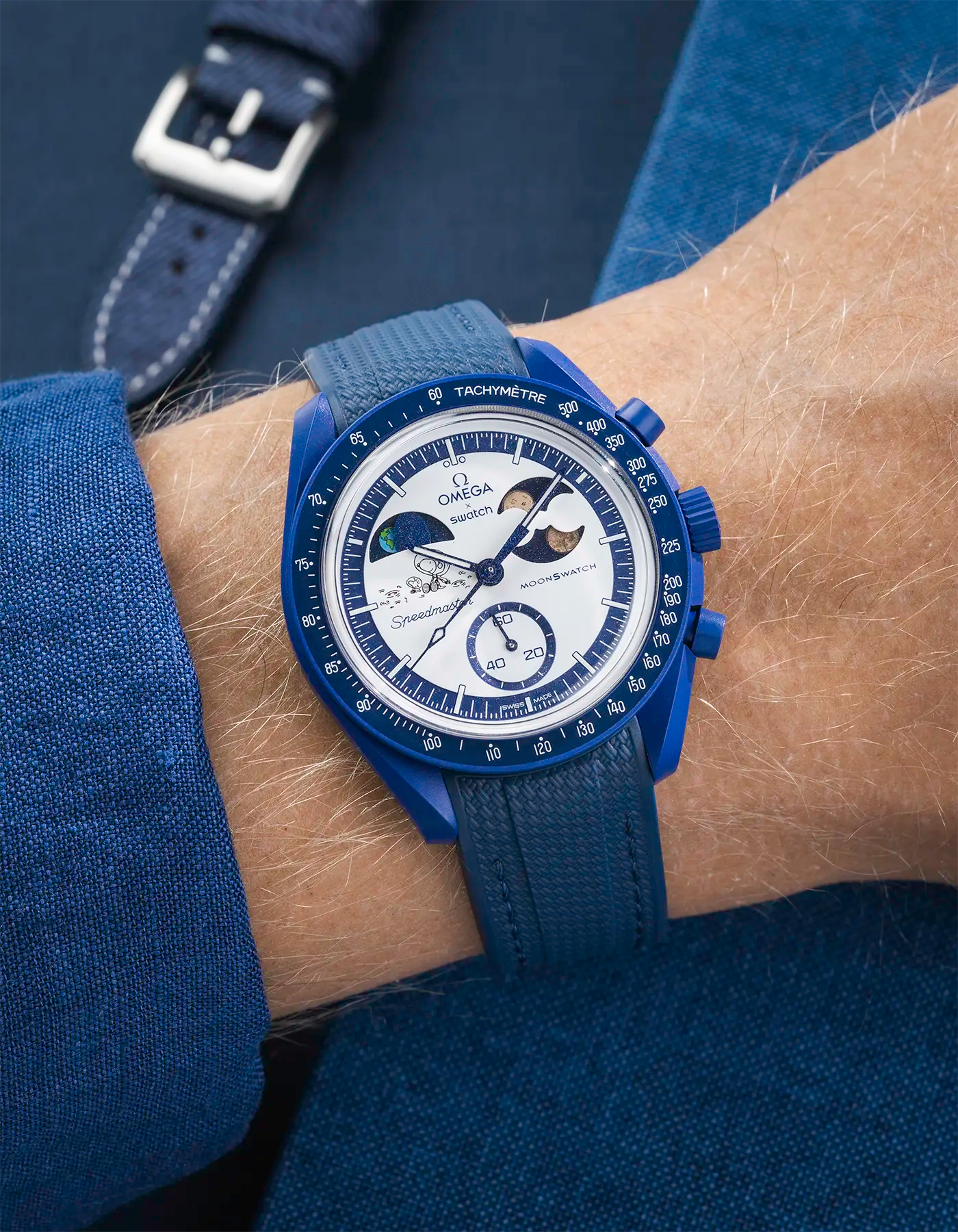 Wrist shot on blue Rubber Strap For Omega x Swatch MoonSwatch Mission To Earthphase - Moonshine Gold with blue background