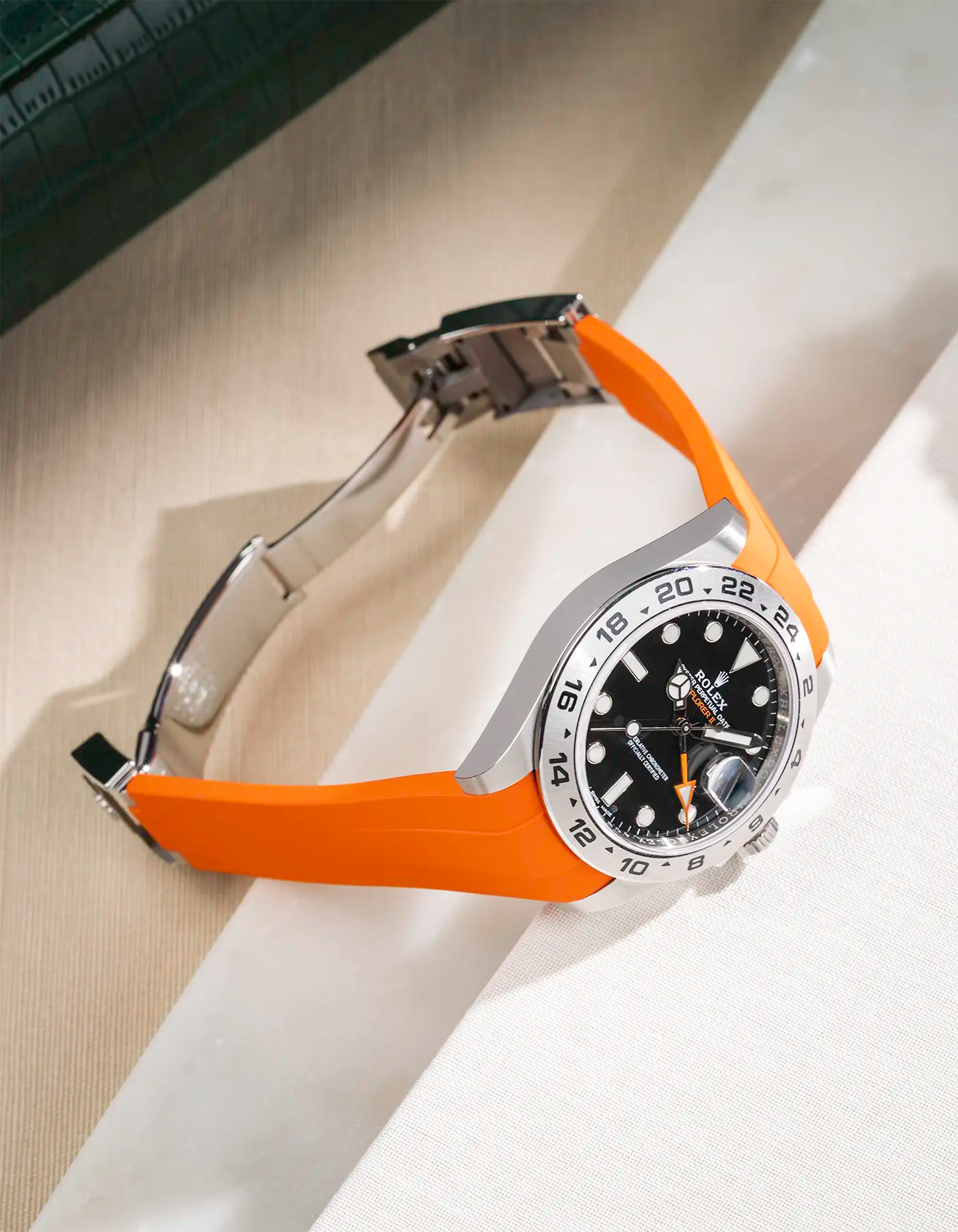 FKM rubber strap integrated with original clasp for Rolex Explorer 216570 in classic smooth orange, displayed on table with open clasp