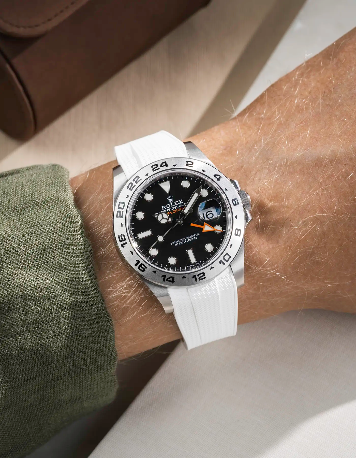 Wrist shot on White Vertech FKM Rubber Strap Integrated with Original Clasp - Rolex Explorer 216570 over a table with brown watch roll