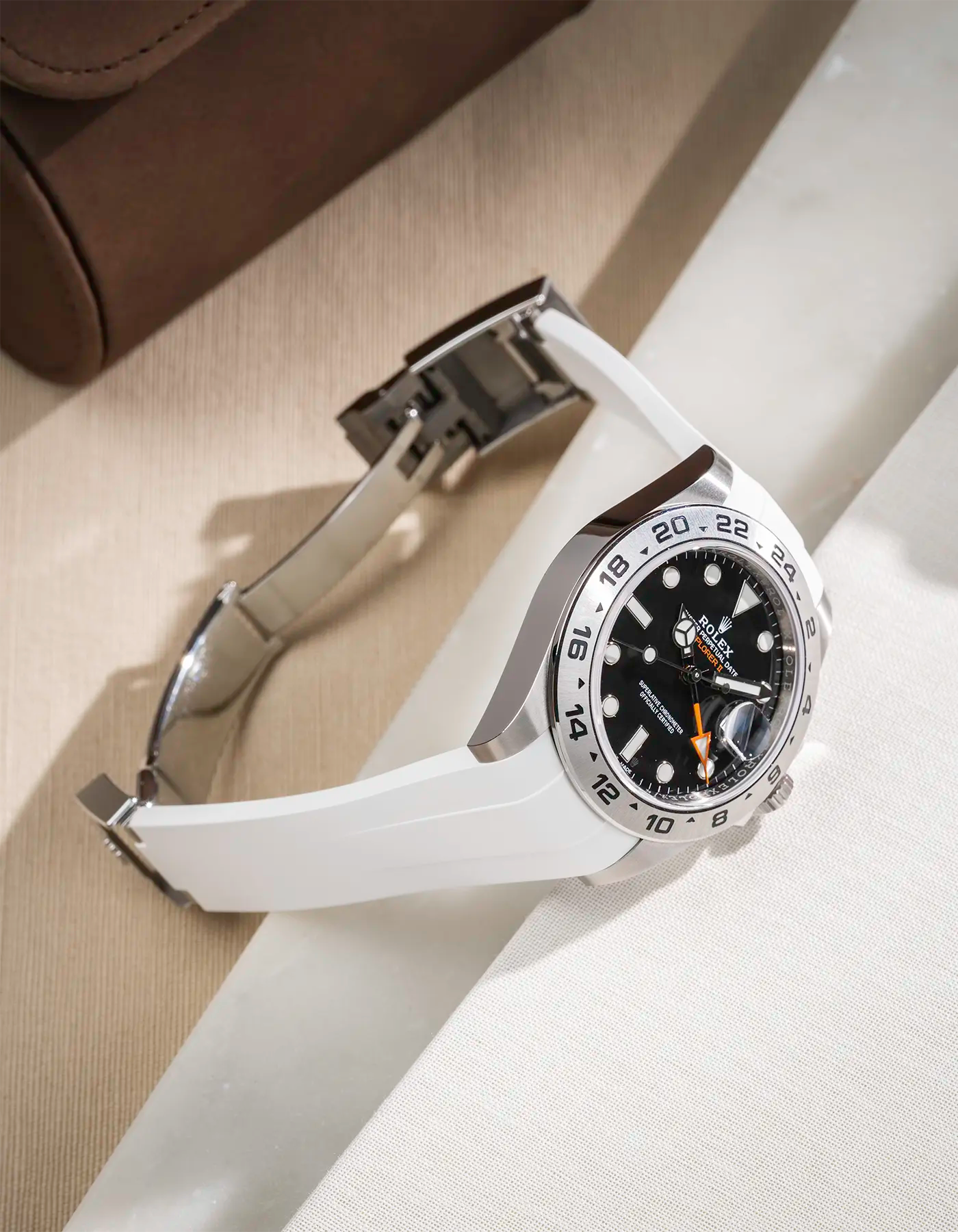 White FKM rubber strap integrated with original clasp for Rolex Explorer 216570, displayed on a beige table with open clasp