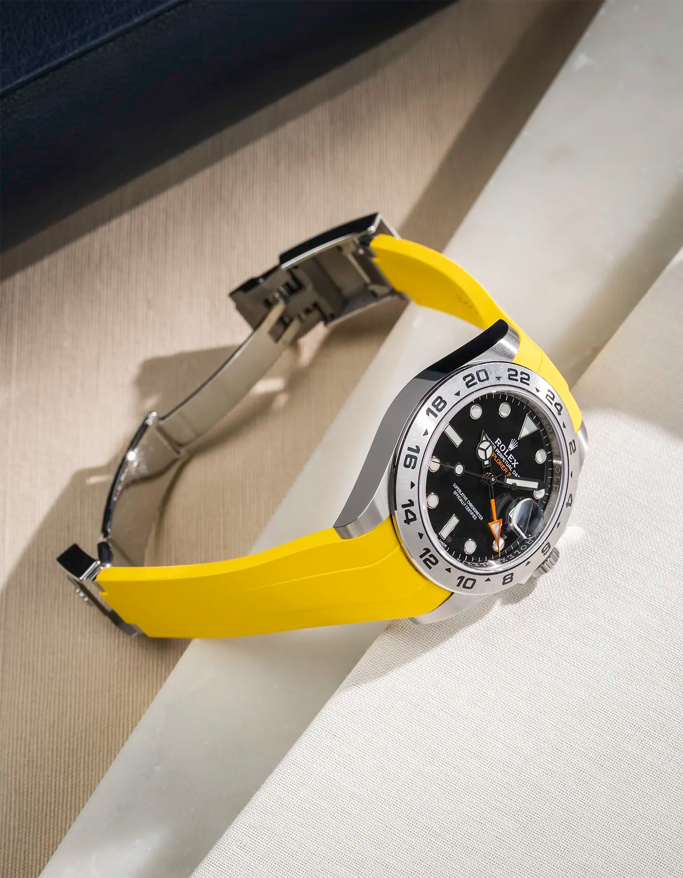 Yellow FKM rubber strap integrated with original clasp for Rolex Explorer 216570, displayed on table with open clasp