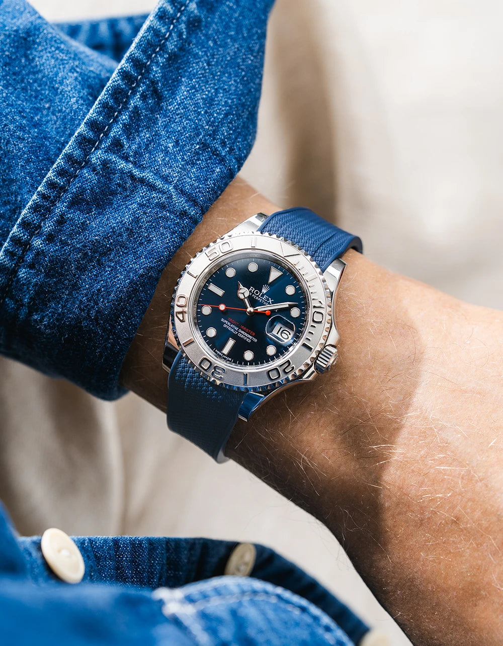 Close-up of a person wearing a Rolex YachtMaster 2 126622 / 116622 model watch with a dark blue shirt sleeve and a navy blue vertech FKM rubber watch strap from Wristbuddys