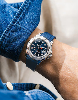Close-up of a person wearing a Rolex YachtMaster 2 126622 / 116622 model watch with a dark blue shirt sleeve and a navy blue vertech FKM rubber watch strap from Wristbuddys