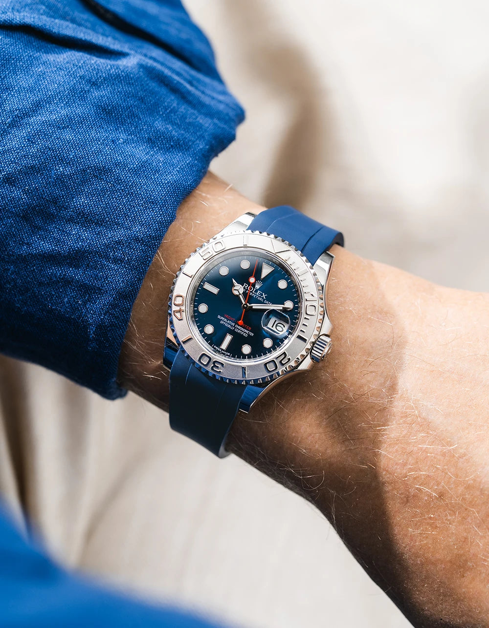 Close-up of a person wearing a Rolex YachtMaster 2 126622 / 116622 model watch with a dark blue shirt sleeve and a navy blue FKM rubber watch strap from Wristbuddys