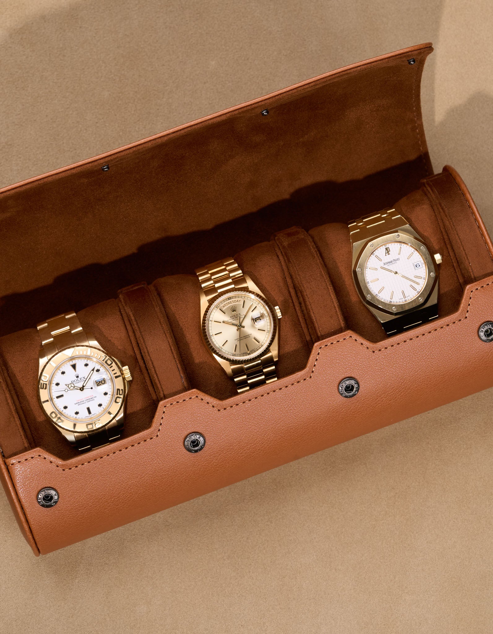 Opened 3 Slot Watch Roll in brown with three luxury gold watches inside
