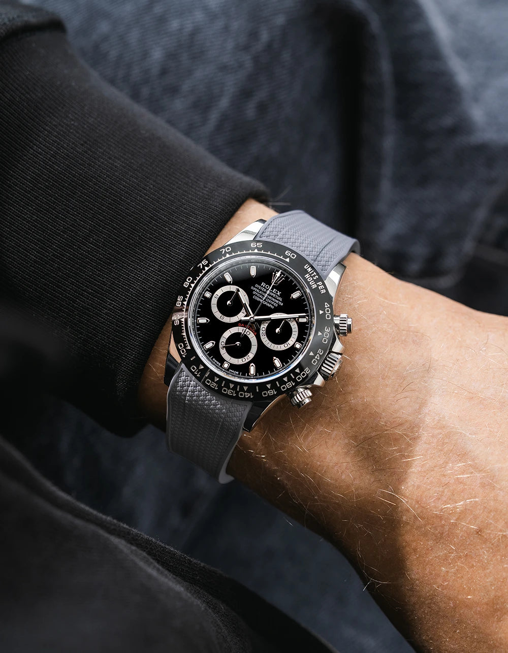 Grey integrated Vertech FKM rubber strap with original clasp on Rolex Daytona 116500 black dial ceramic bezel wrist shot textured surface