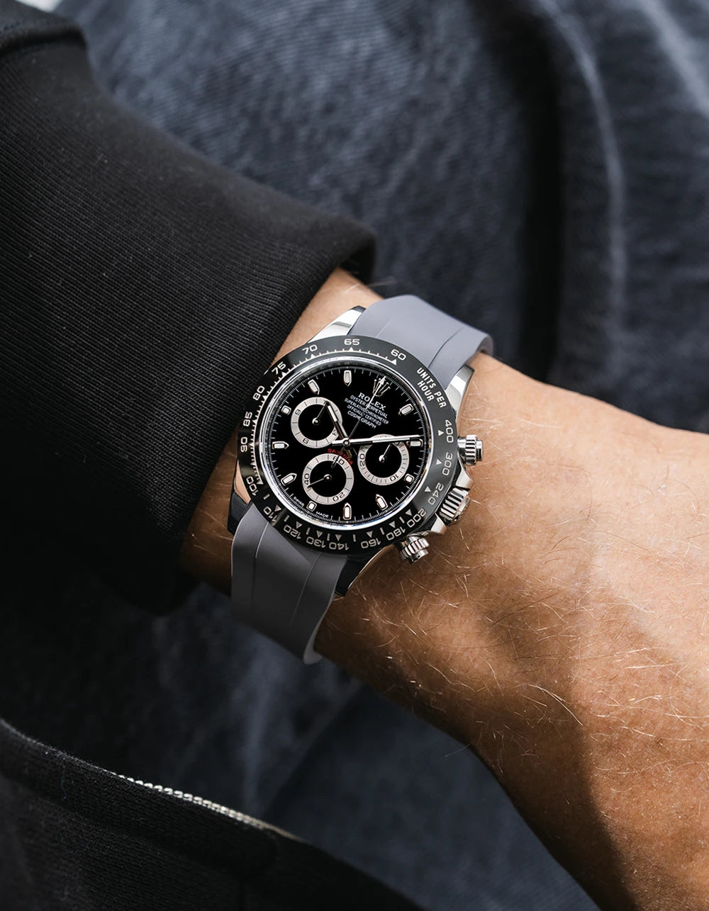 Grey integrated FKM rubber strap with original clasp on Rolex Daytona 116500 black dial ceramic bezel wrist shot classic smooth surface