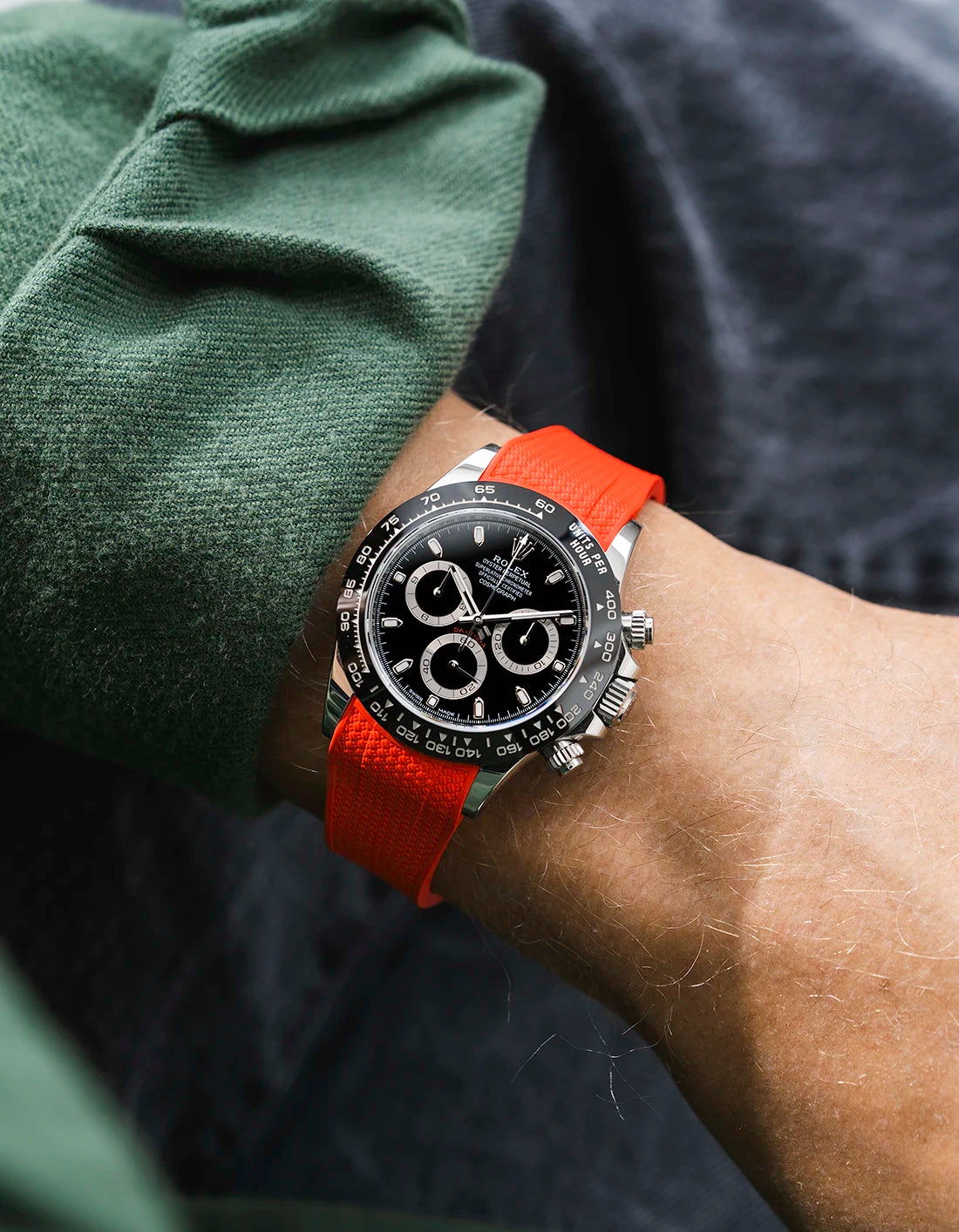 Red integrated Vertech FKM rubber strap with original clasp on Rolex Daytona 116500 black dial ceramic bezel wrist shot textured surface