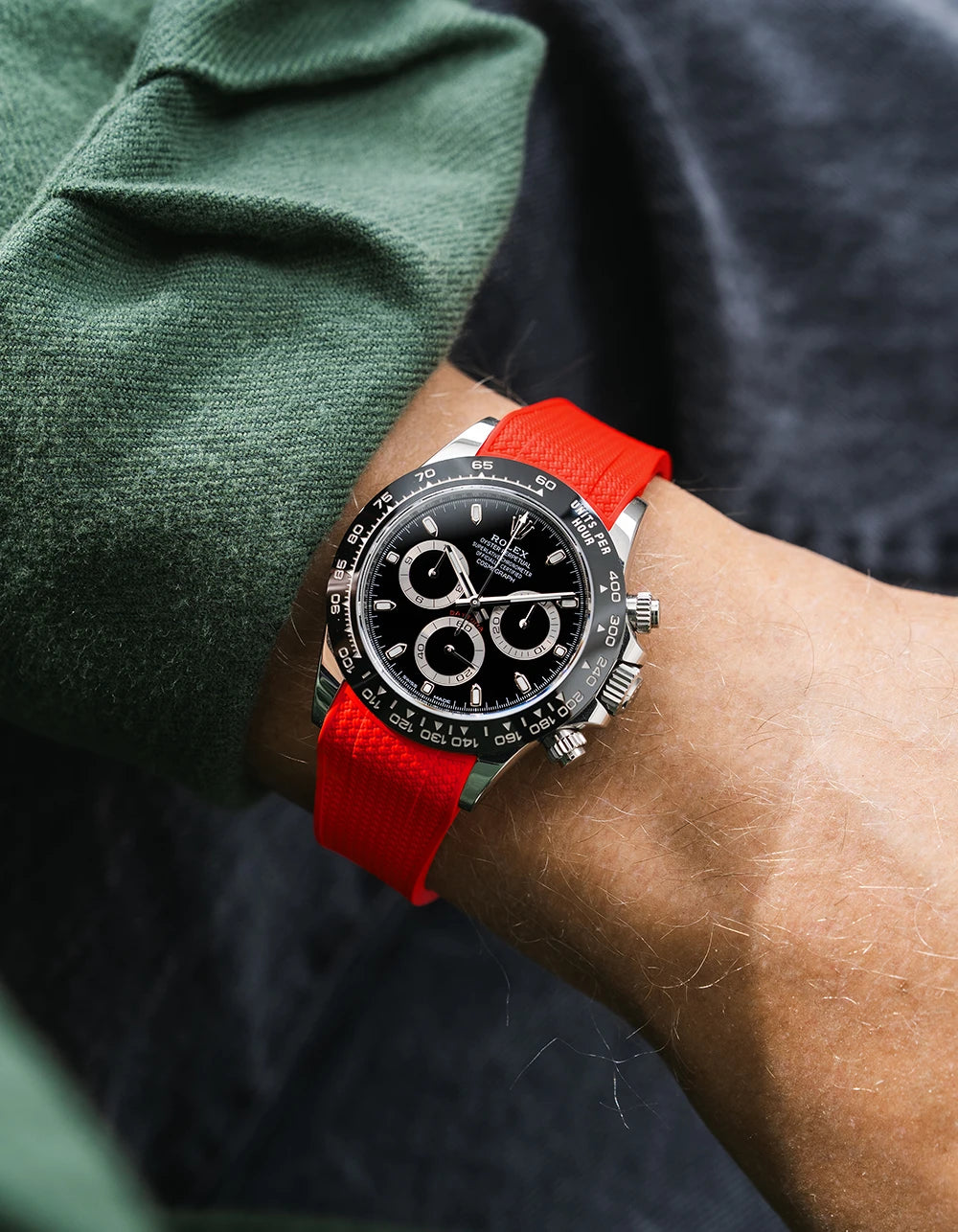 Red integrated Vertech FKM rubber strap with original clasp on Rolex Daytona 116500 black dial ceramic bezel wrist shot textured surface