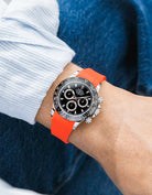 Red integrated FKM rubber strap with original clasp on Rolex Daytona 116500 black dial ceramic bezel wrist shot classic smooth surface