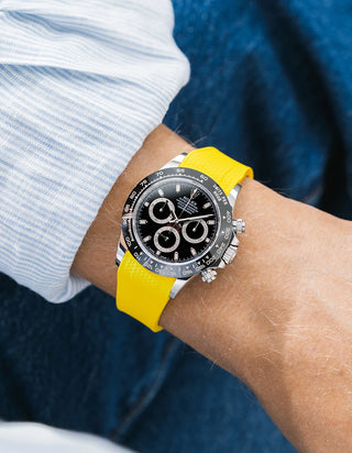 Yellow integrated Vertech FKM rubber strap with original clasp on Rolex Daytona 116500 black dial ceramic bezel wrist shot textured surface