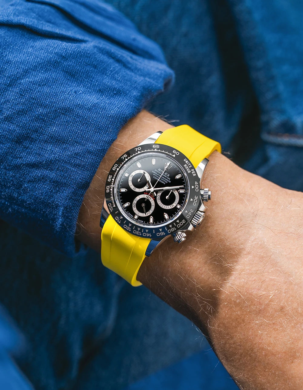 Yellow integrated FKM rubber strap with original clasp on Rolex Daytona 116500 black dial ceramic bezel wrist shot classic smooth surface