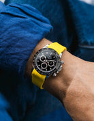 Yellow integrated FKM rubber strap with original clasp on Rolex Daytona 116500 black dial ceramic bezel wrist shot classic smooth surface