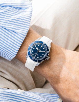 Wristbuddys white rubber strap on Tudor Black Bay 58 Navy Blue — wrist lifestyle shot with striped shirt